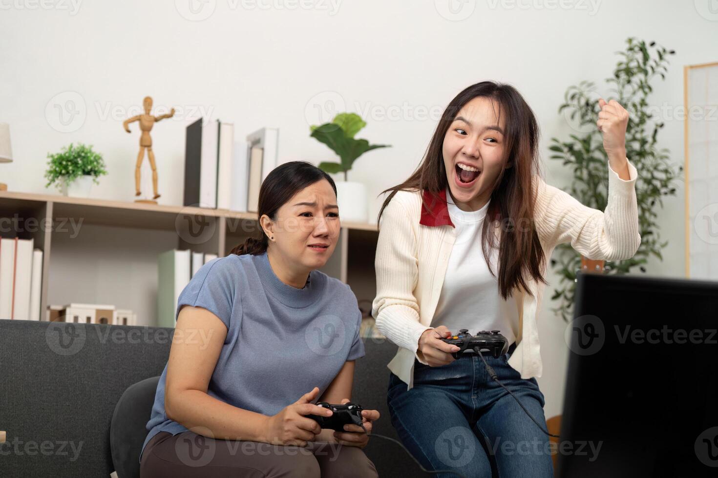 Mother and Daughter Bonding over Games. Excitement and Fun in a Cozy Living Room. photo