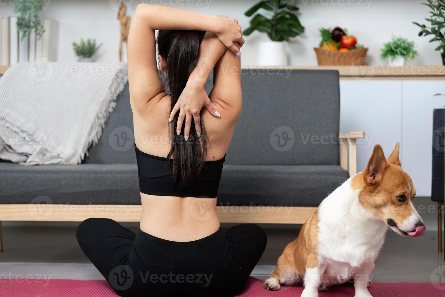 Mindfulness and Stretching. Woman practicing yoga with her dog in a serene home environment. photo