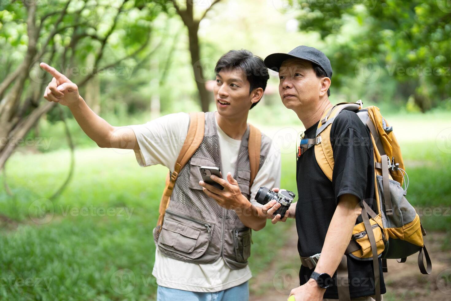 Father and Son Exploring Nature. A young man and his father enjoying a hike in the woods. photo
