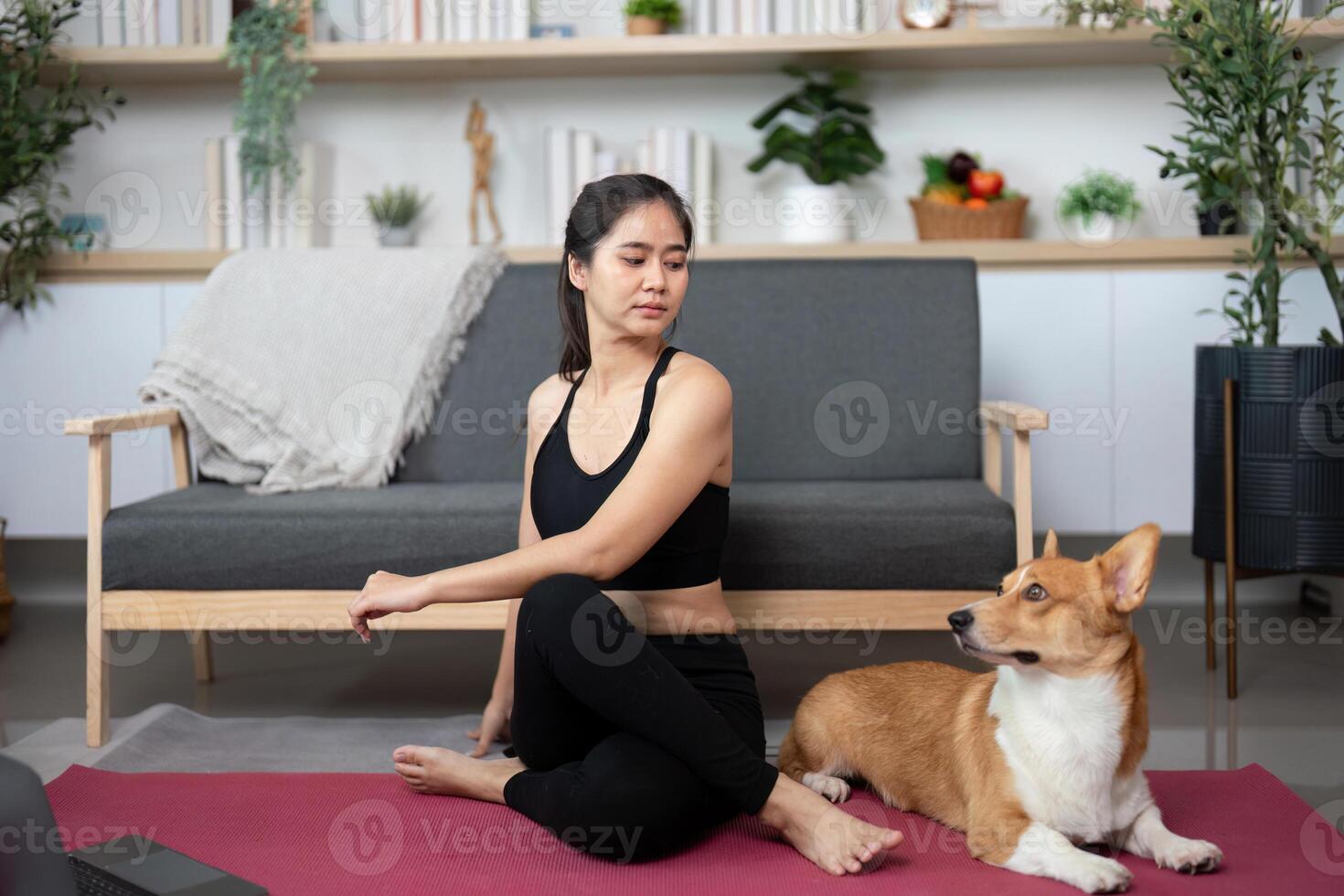 Yoga and Dog Companionship. Woman practicing yoga with her corgi in cozy living room. photo