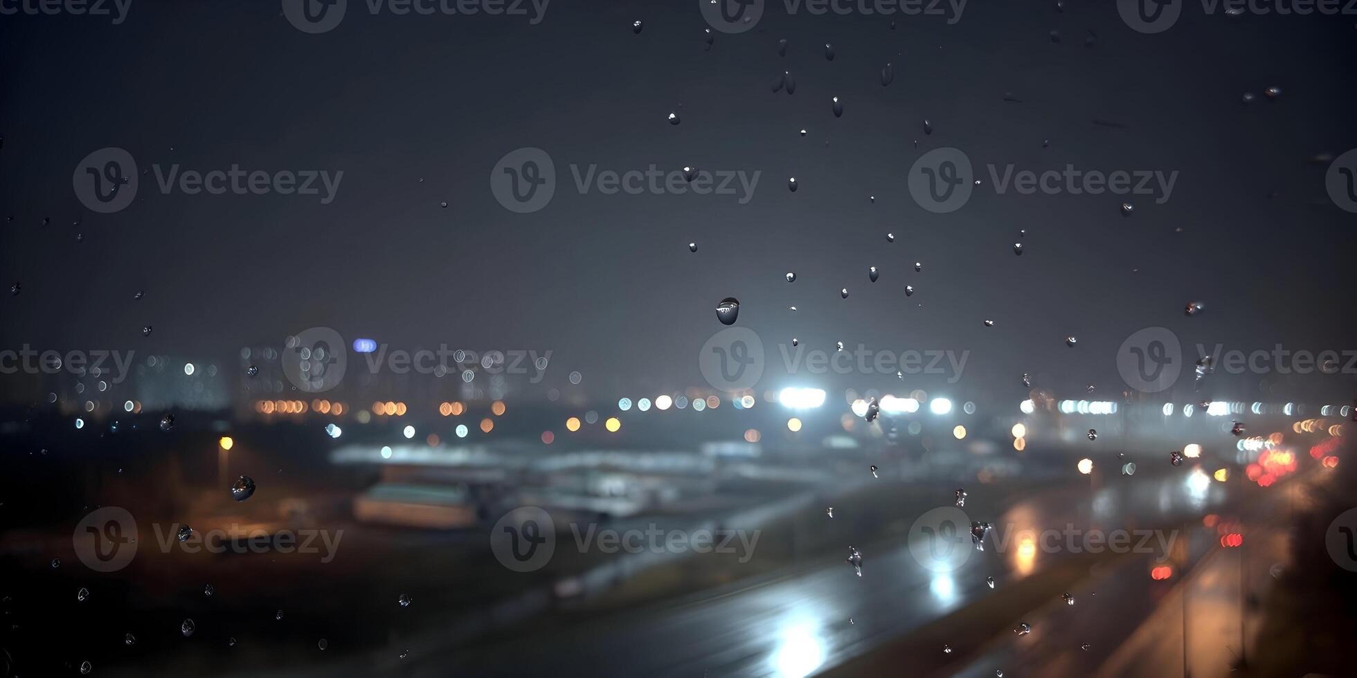 Rainy Night View of Urban Skyline Behind Wet Glass photo