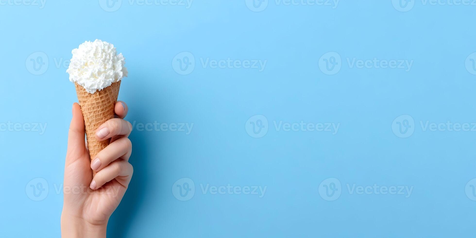 Woman Holding Waffle Cone with Whipped Cream on Blue Background photo