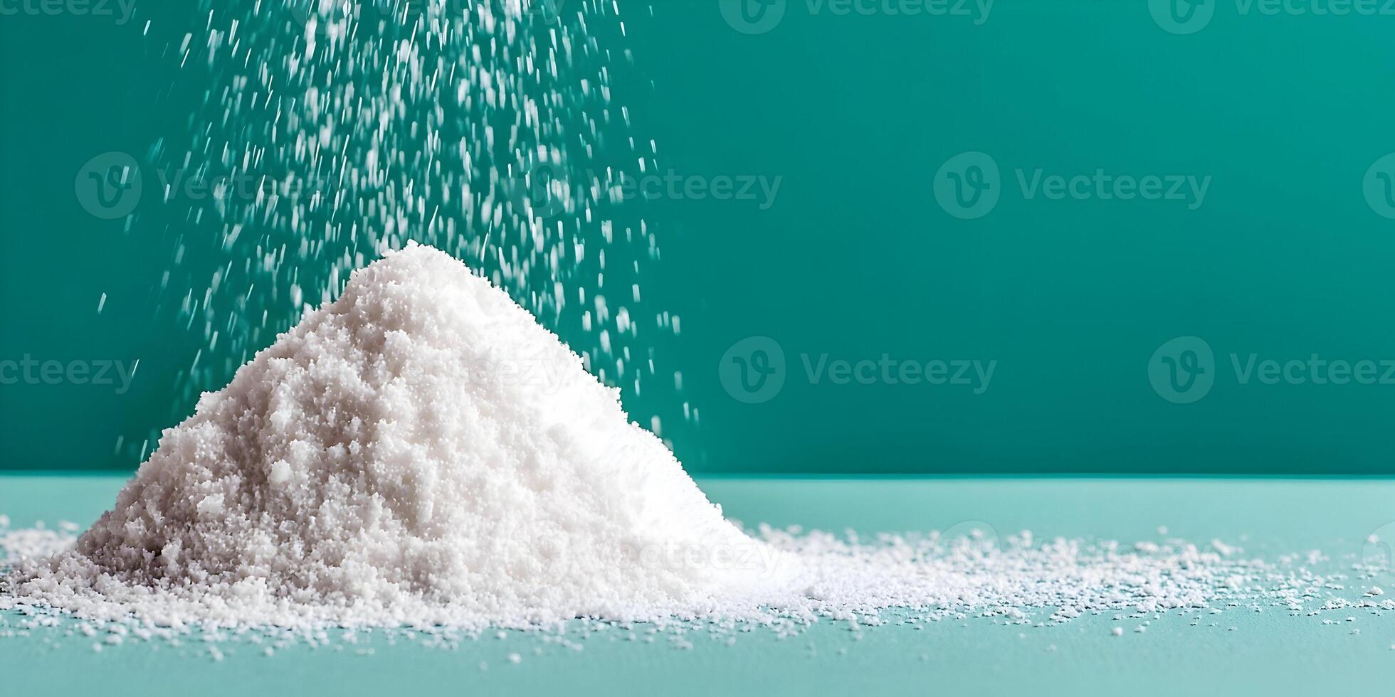 White Powder Pile on Teal Background Falling Powder Grains photo
