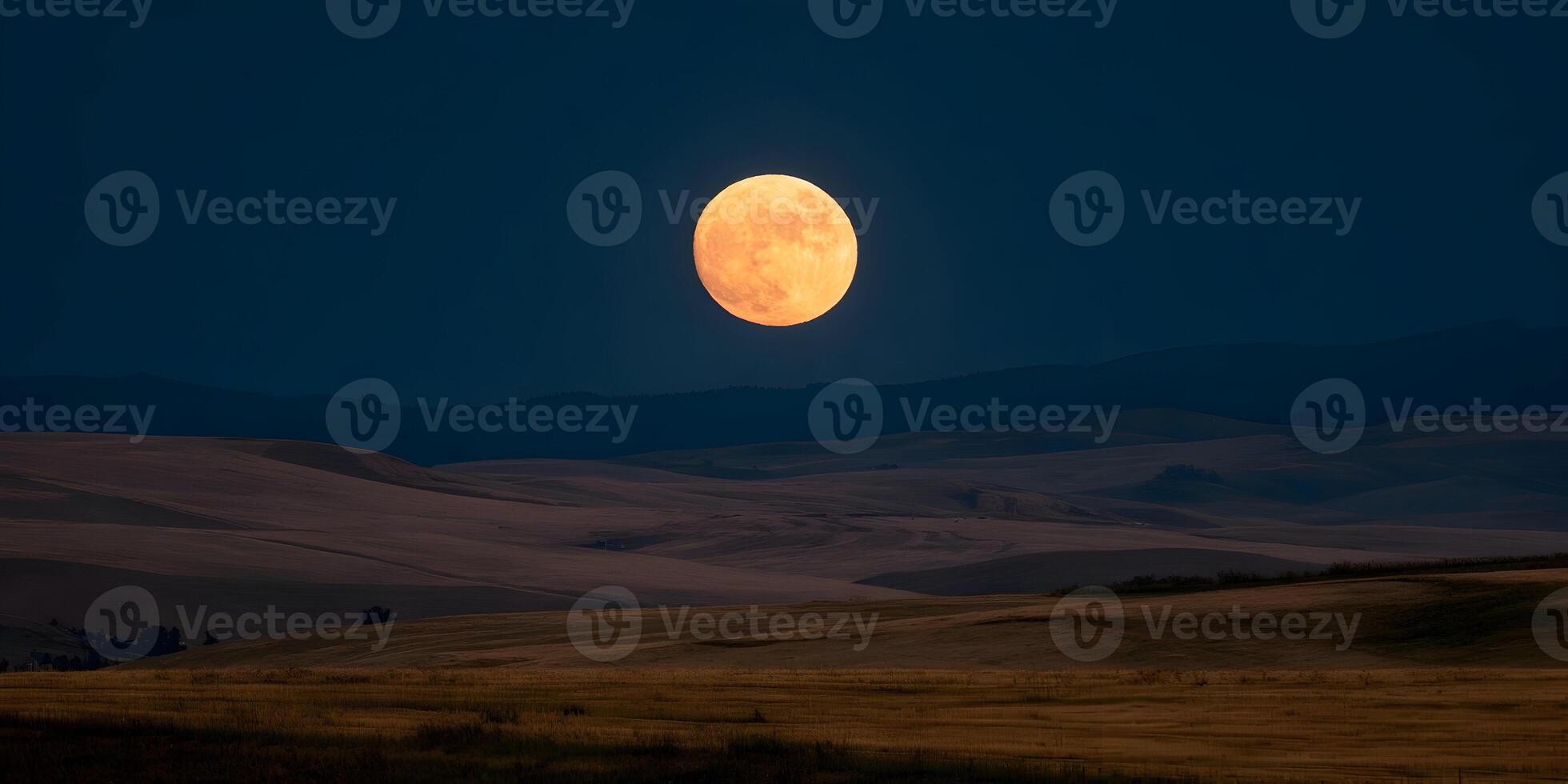 Large Orange Full Moon Over Rolling Hills Landscape at Night photo