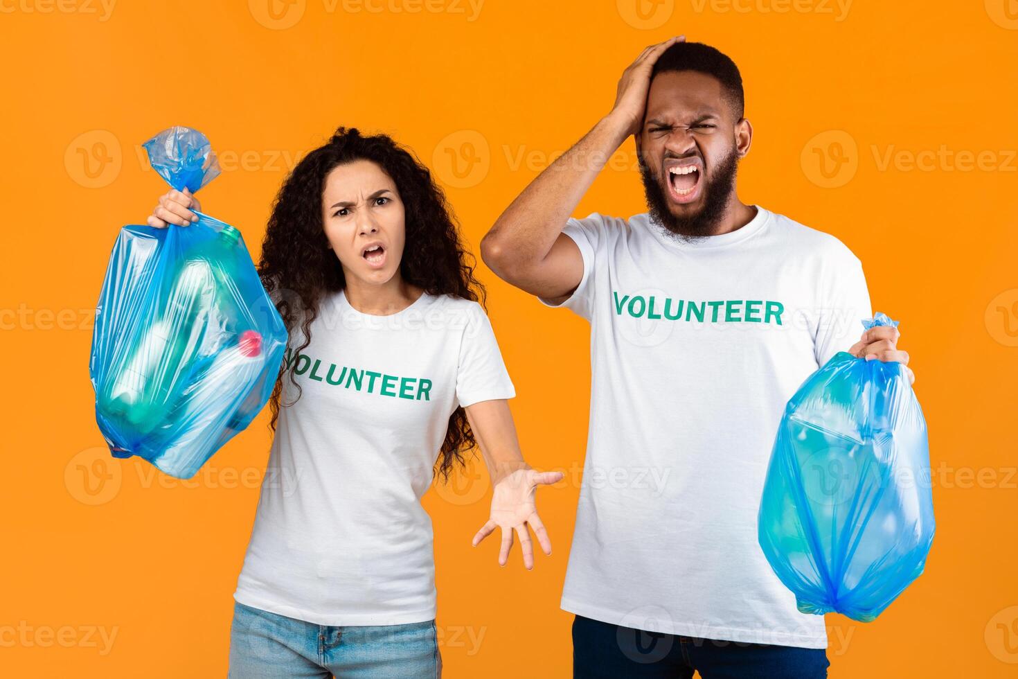 Don't Litter. Two Angry Volunteers Man And Woman Shouting Holding Blue Garbage Bags Posing Over Yellow Studio Background. Volunteering Work, Stop Using Plastic Concept photo