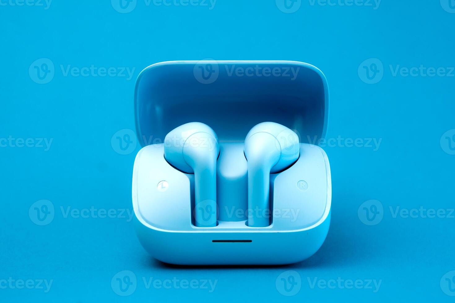 A pair of stylish wireless earbuds inside an open charging case, set against a vibrant blue background. Compact, portable, and modern design, ideal for music lovers and tech enthusiasts photo