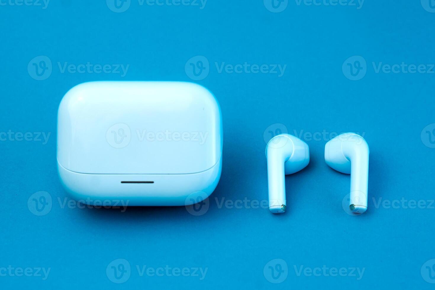 A stylish pair of wireless earbuds with a closed charging case on a blue background. The compact and modern design makes it ideal for music, calls, and on-the-go listening. photo