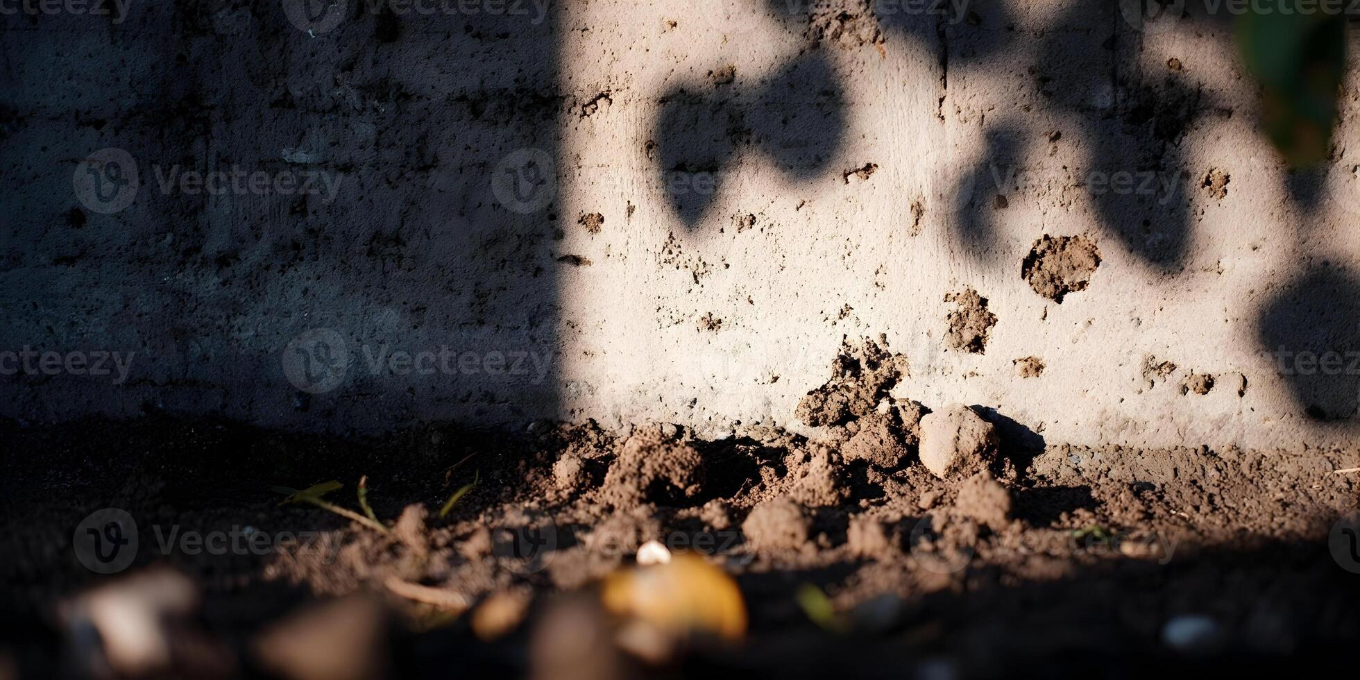 Sunlight Shadow on Weathered Concrete Wall and Soil Ground photo