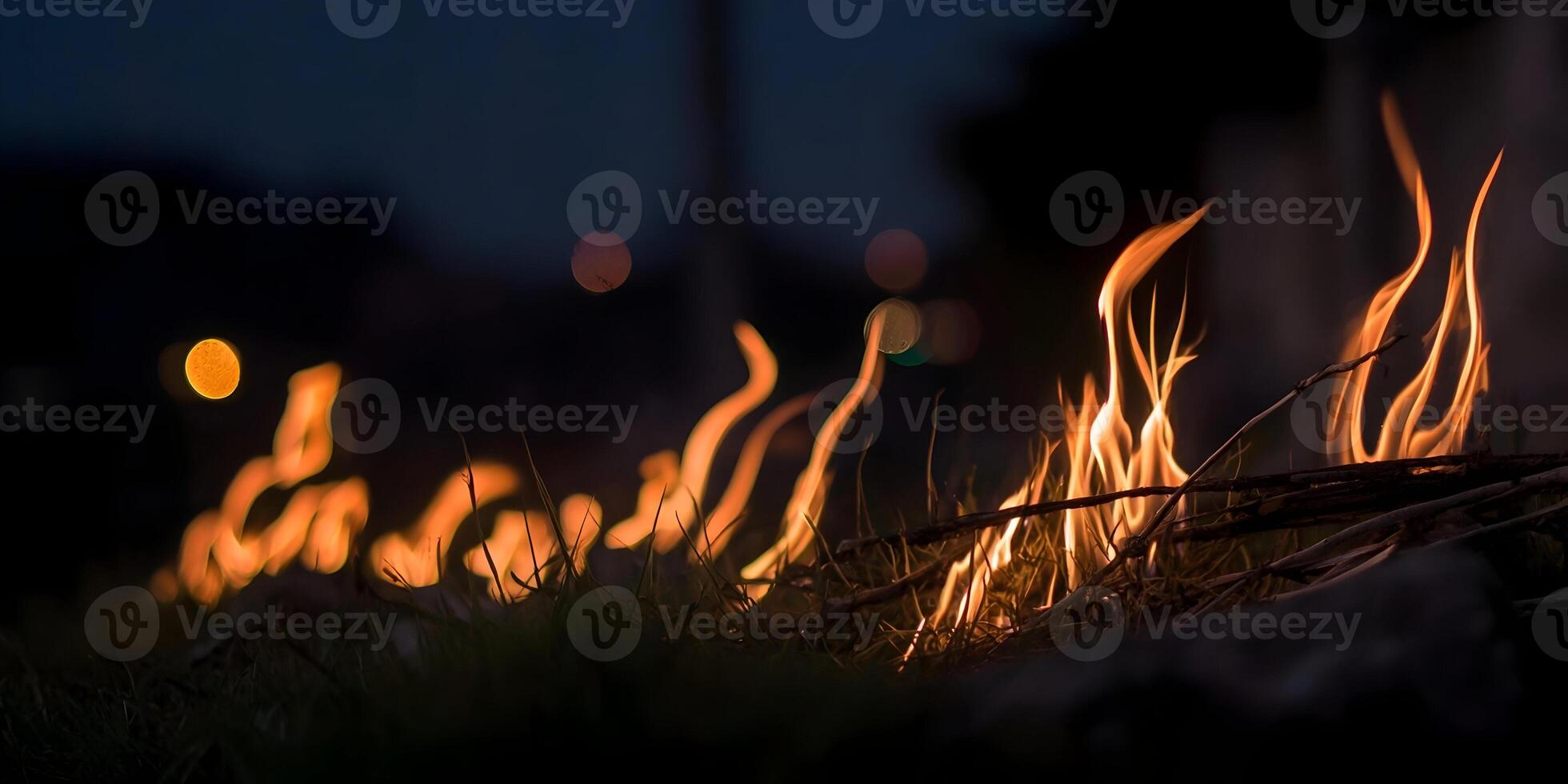 Nighttime Bonfire Flames Burning in Grass with Bokeh Lights photo