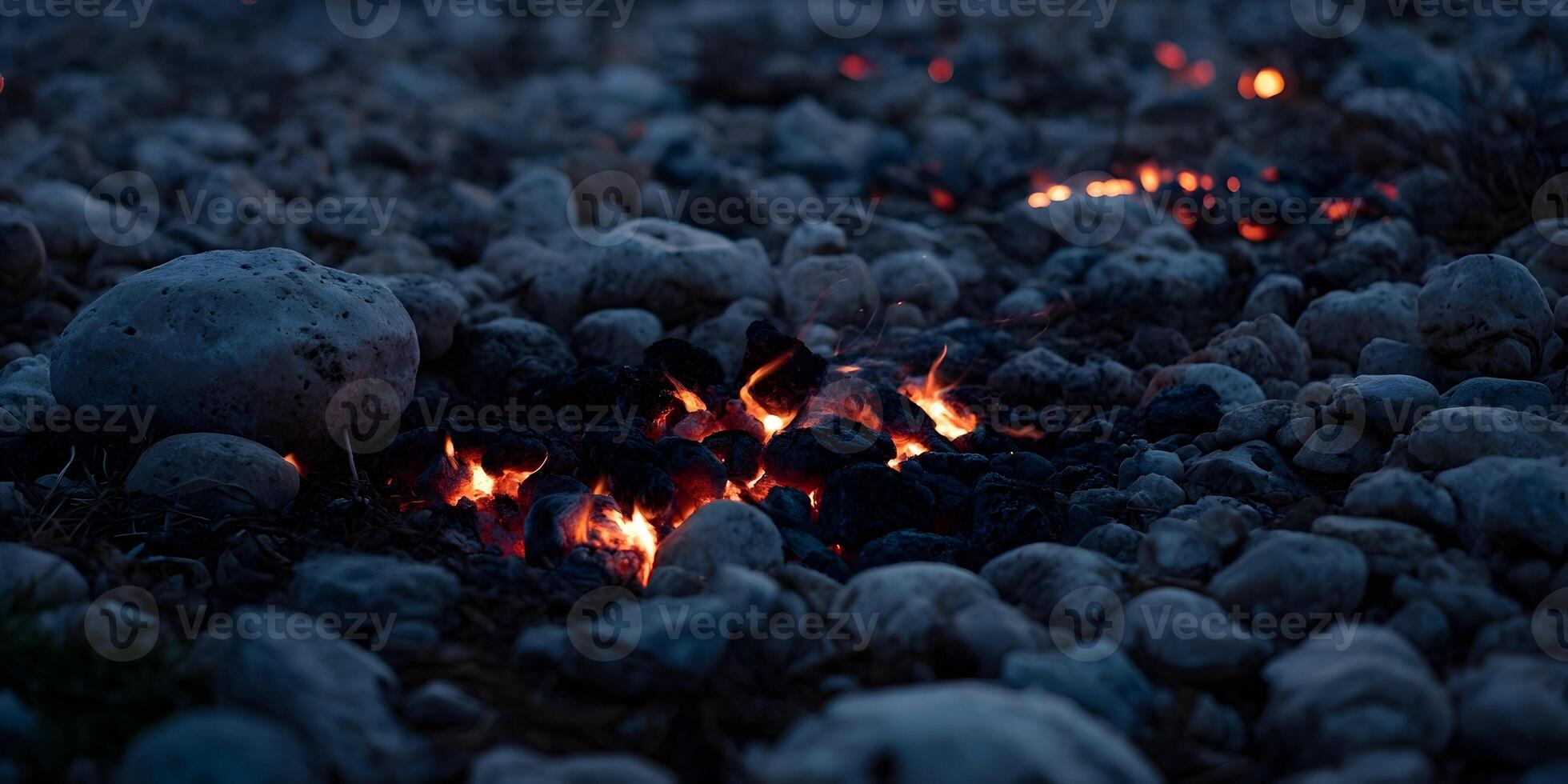 Embers glowing in dark rocks at night small fire in stones photo
