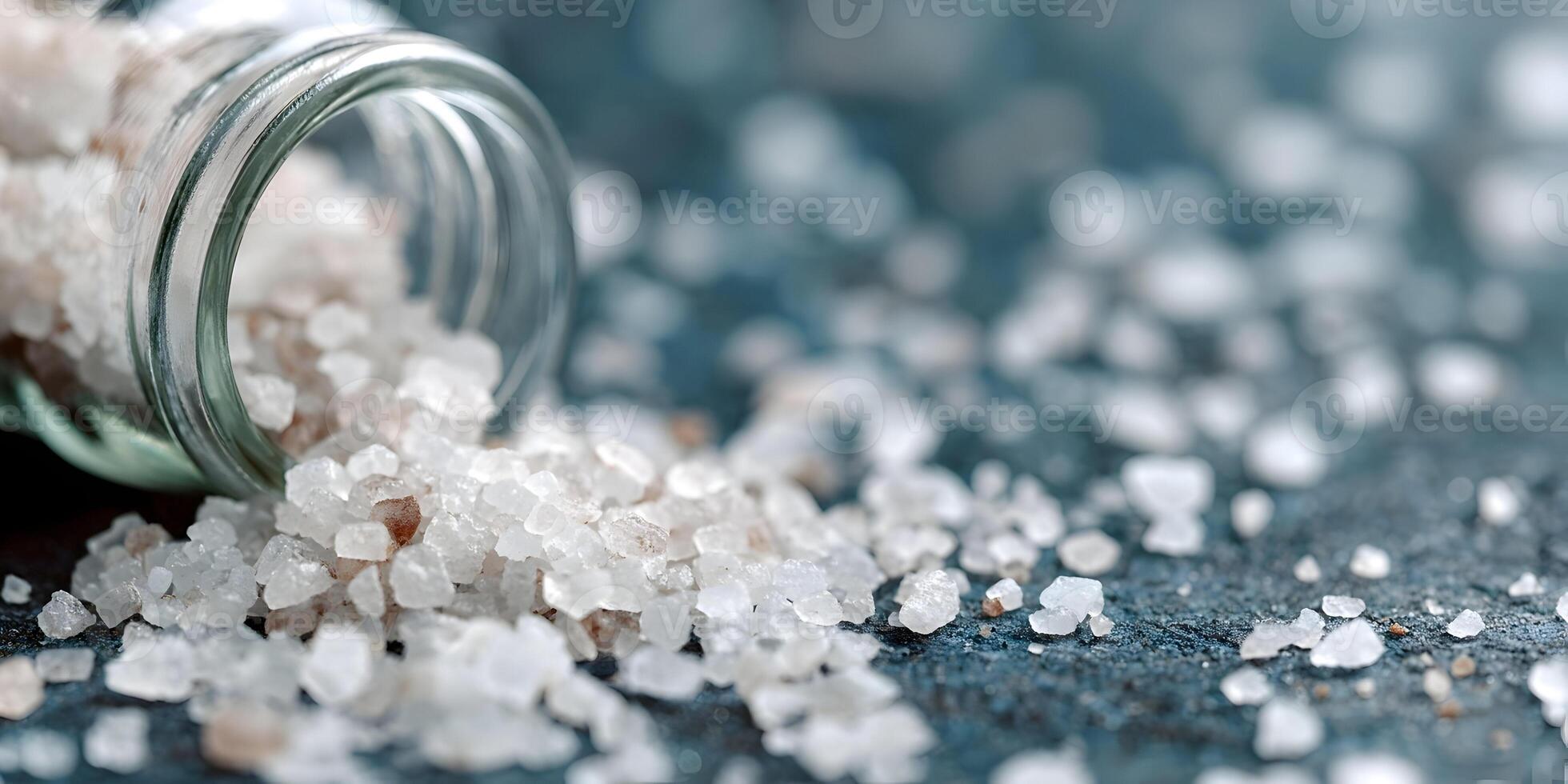 Pink Himalayan Salt Crystals Spilled from Glass Jar on Dark Background photo