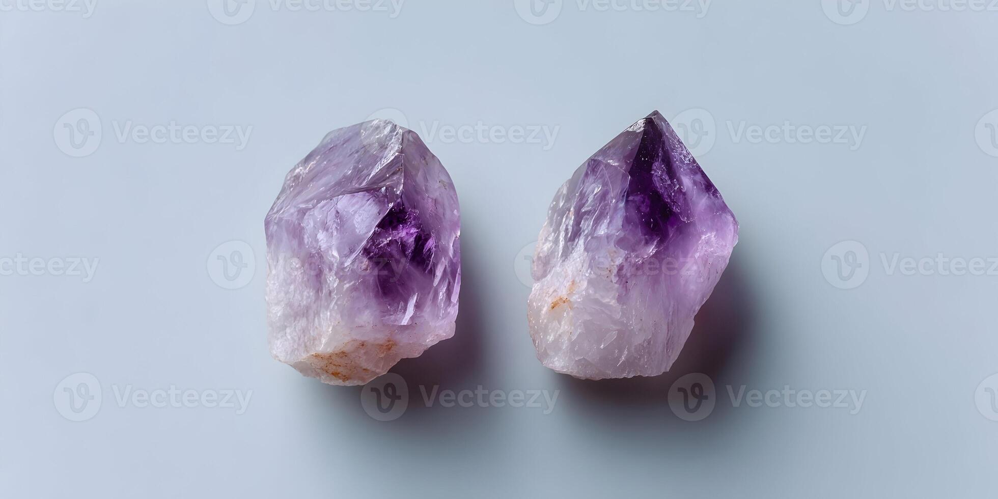 Two Amethyst Crystal Clusters on Light Gray Background photo