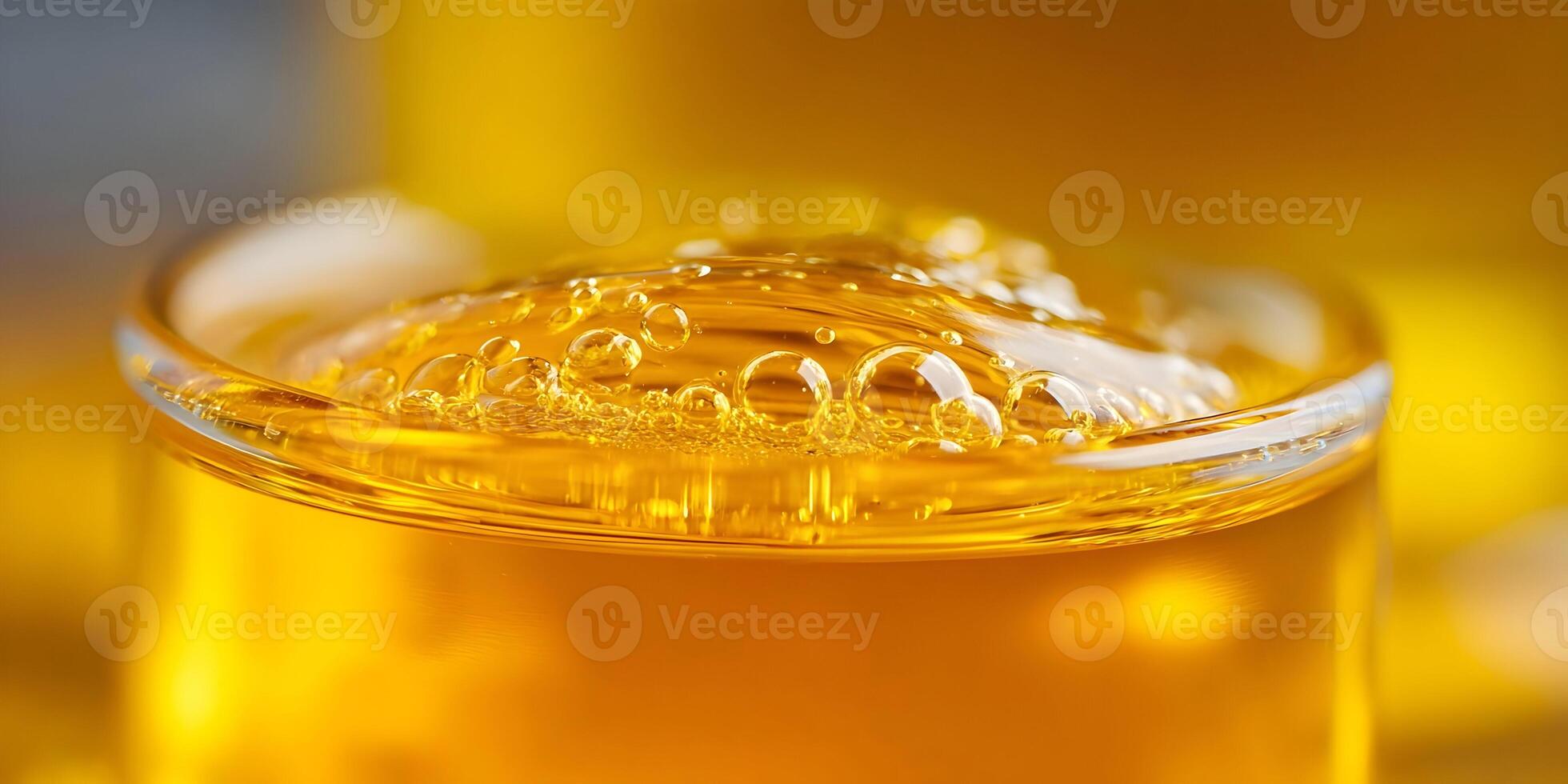 Closeup of Glass Filled with Golden Liquid and Bubbles photo
