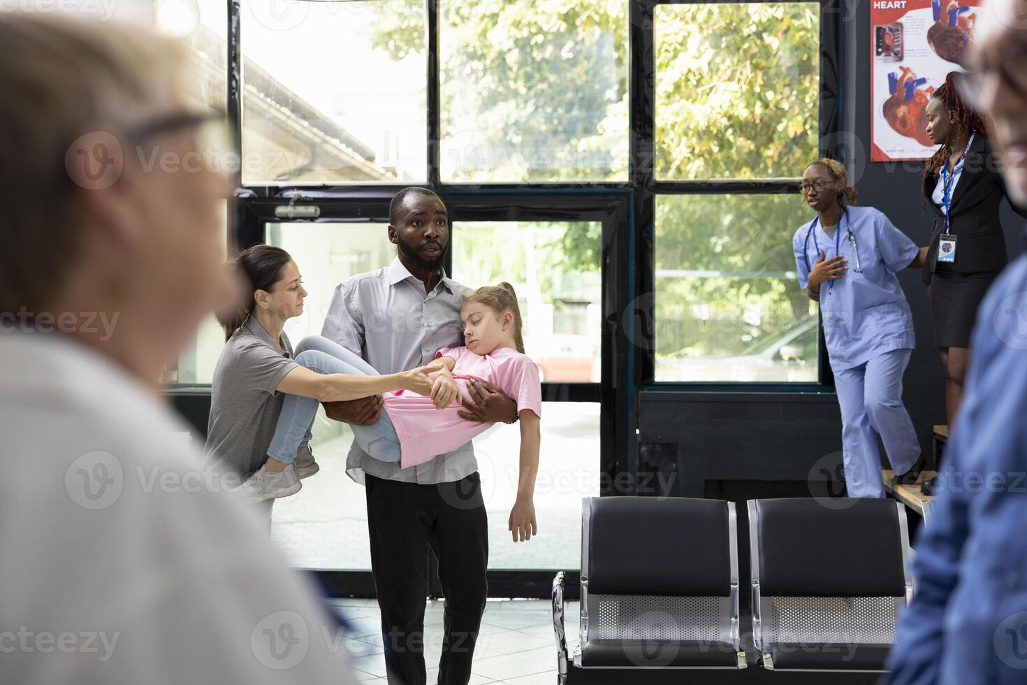 Young kid faints in her father arms with worried mother by her side, as african american team provides first aid and assistance during pediatric emergency and family health scare. photo