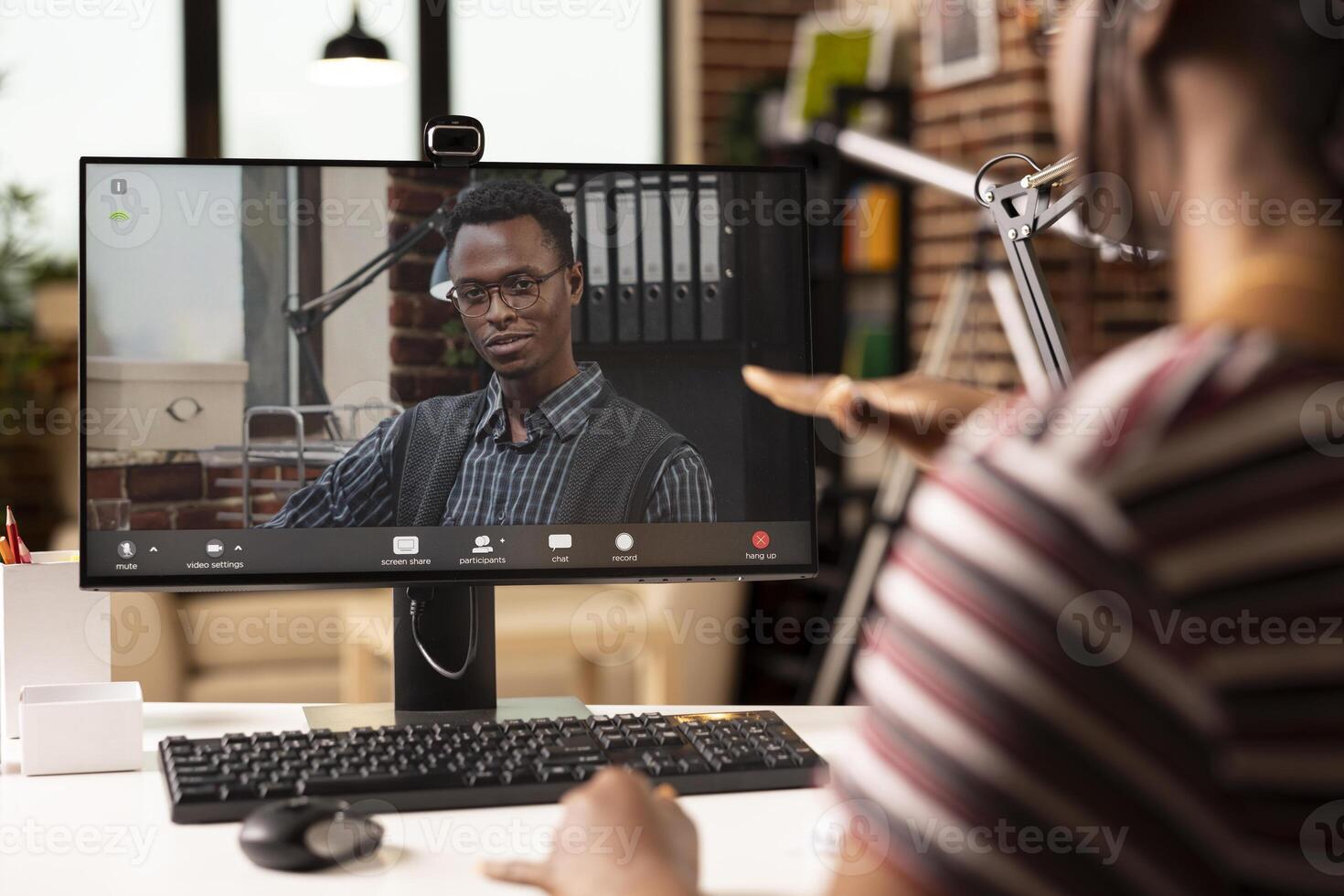Male business advisor seen on computer screen, providing insights on strategy plans to black female entrepreneur during call. African american individuals having virtual meeting on desktop pc. photo