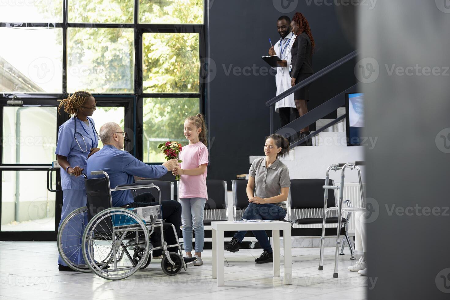 Young child offering flowers to grandfather wheelchair user during patient visit, showing intergenerational love and support under hospital safety rules. Kid supporting grandparent. photo