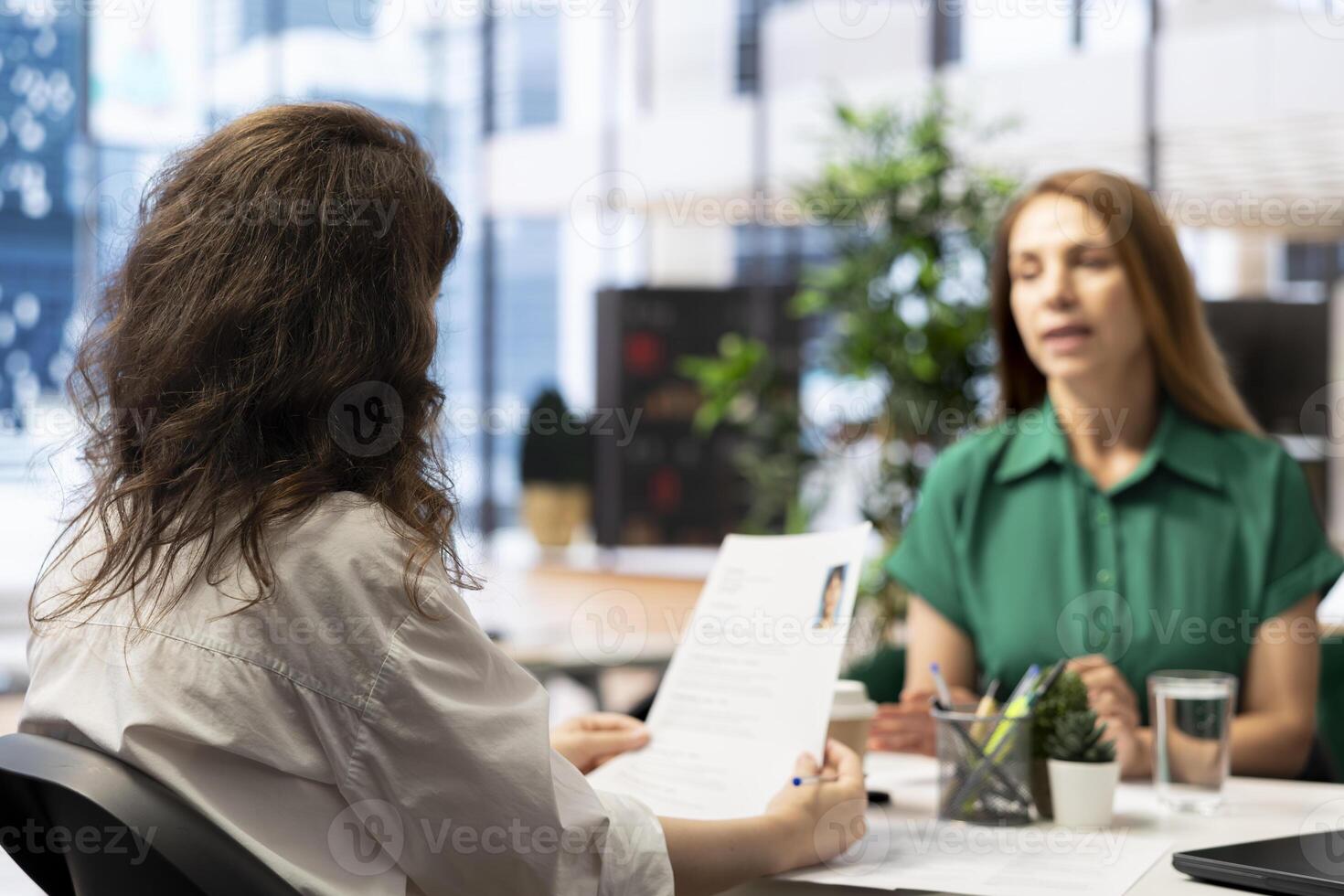 Manager interviewing worker, recruiting for job, discussing business offer in corporate office. Businesswoman hiring candidate after checking CV resume, recruitment concept photo