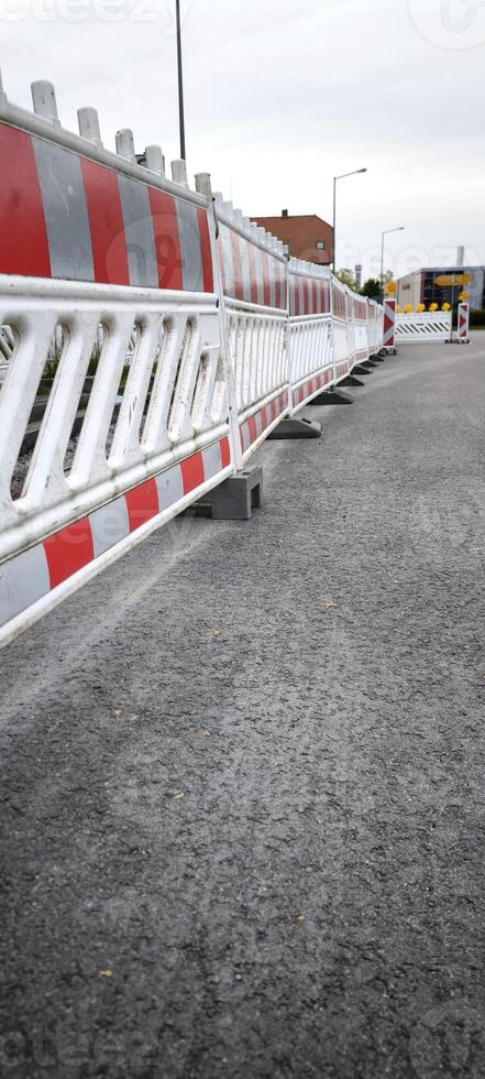On the asphalt road in the city there is a road barrier photo