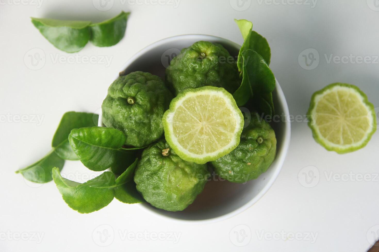 Kaffir lime or bergamot fruit, kaffir lime or citrus hystrix fruit in a white bowl and on a white background isolated photo