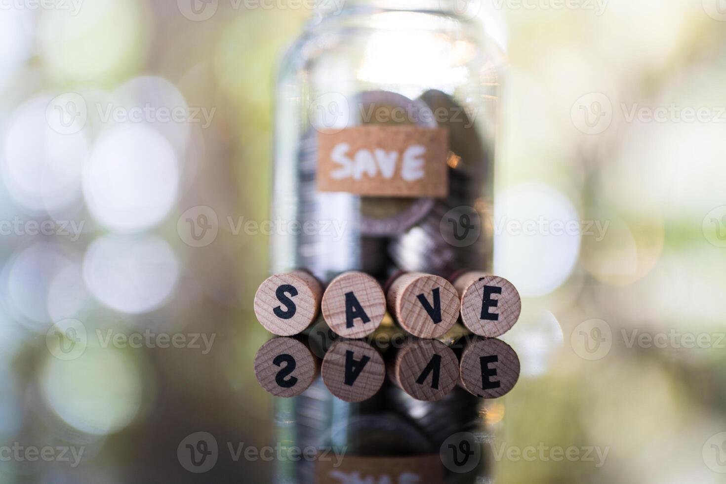 Wooden blocks displaying SAVE in font of glass jar bank fill with coin, symbolizing financial save and growth photo