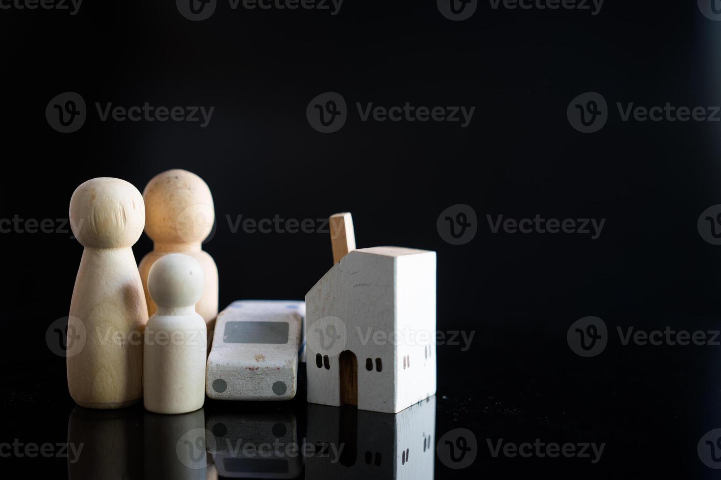 Wooden human family figure peg dolls with home and car. Money saving concept to build a family. photo