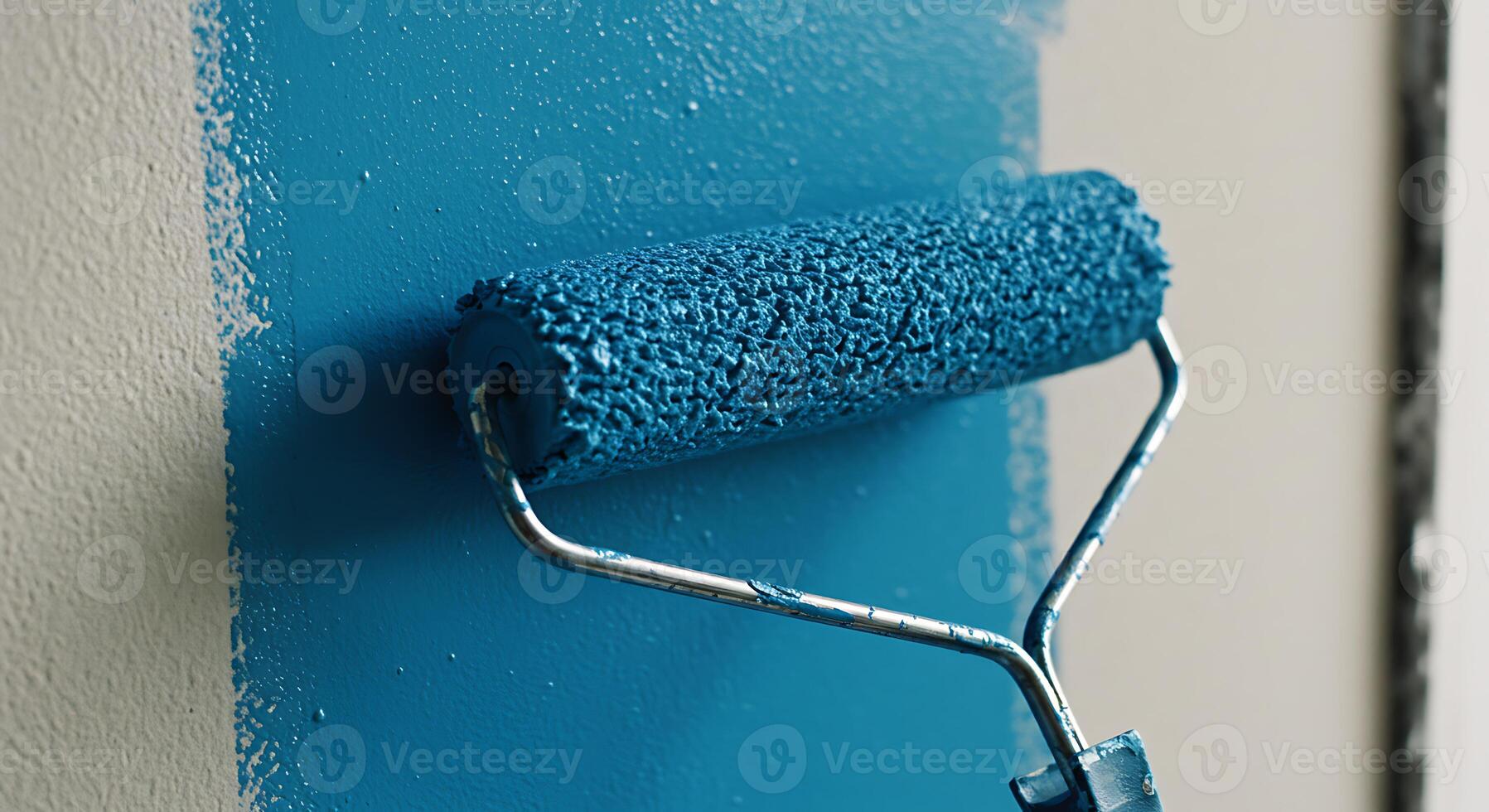 Painting Wall with Blue Color Using a Paint Roller Close Up photo
