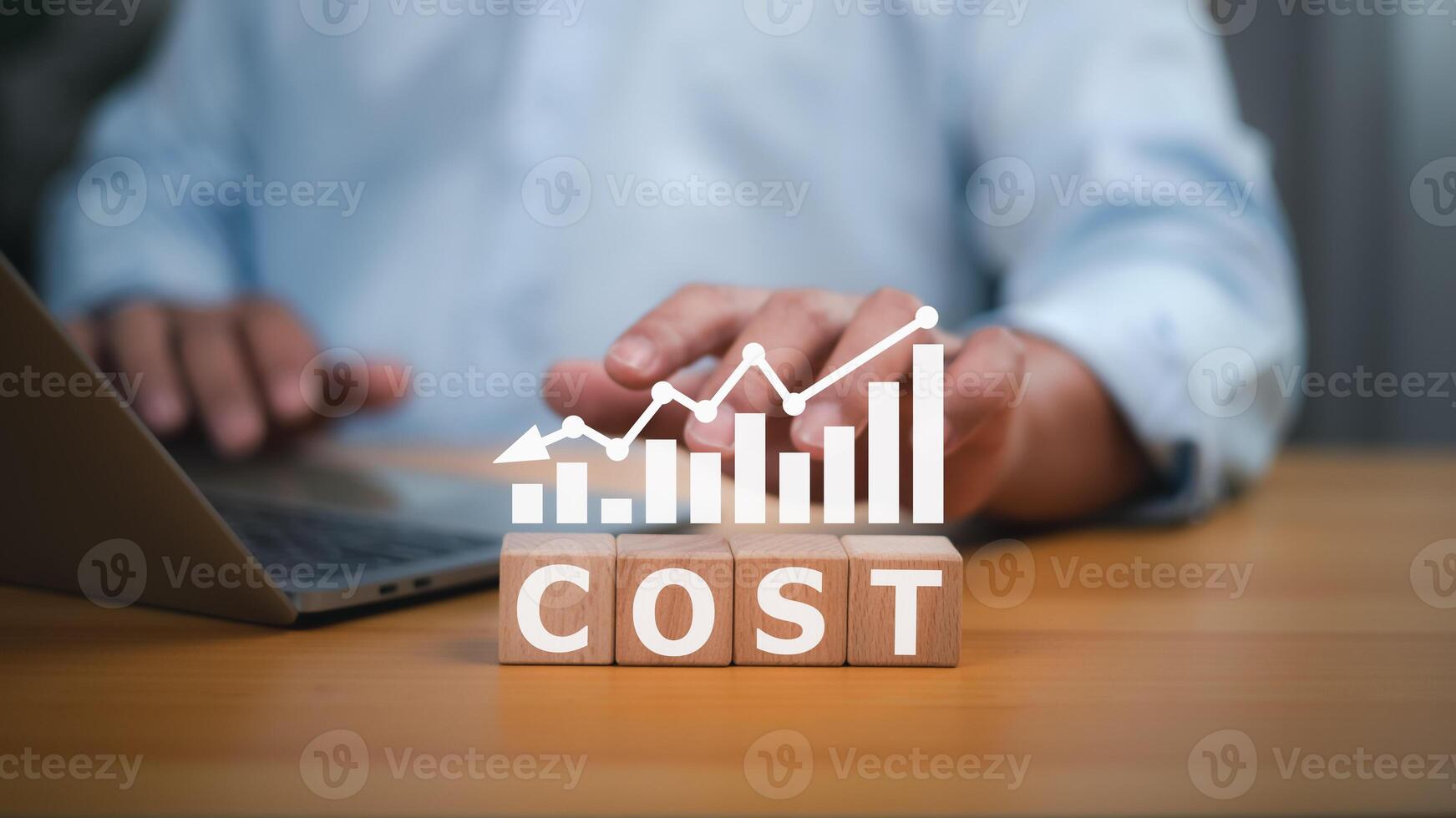 People working and wooden blocks spelling out the word COST, with a graph overlaying a downward trend, representing declining costs, cost analysis, financial management challenges, and economic trends photo