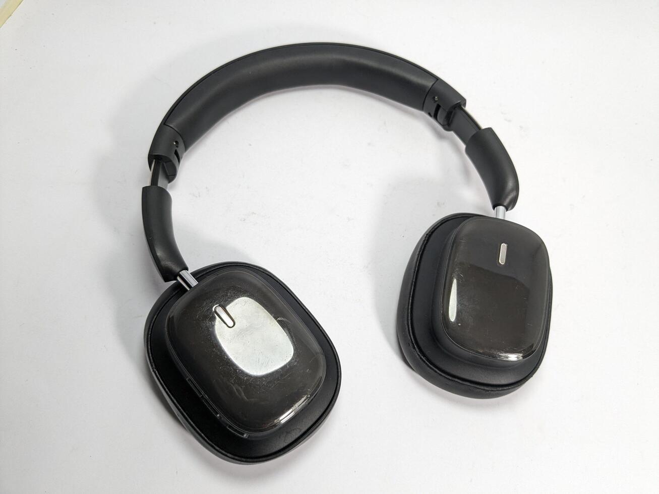 Overhead shot of modern black wireless headphones on a white surface in studio setting. photo