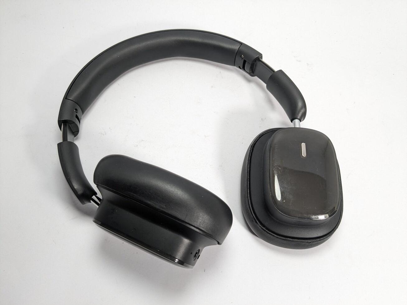 Overhead shot of black wireless headphones on a white surface, studio lighting photo