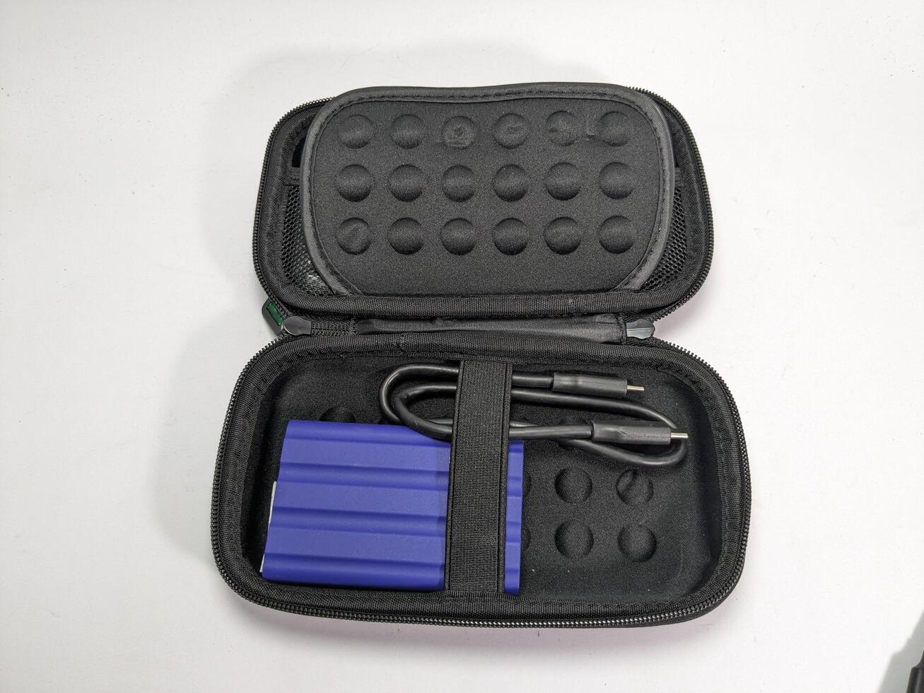 Open Black Case with Blue External Hard Drive and Black USB Cable on White Surface photo