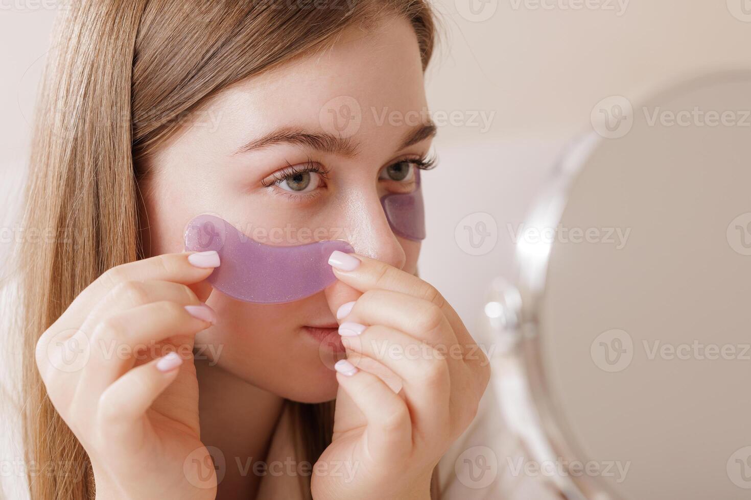 Woman Applying Hydrogel Under Eye Patches for Rejuvenation Wrinkles and Skincare Routine photo
