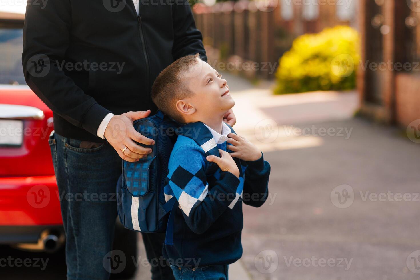 Father supports son with backpack before school, happy child looking up, first day back to school photo