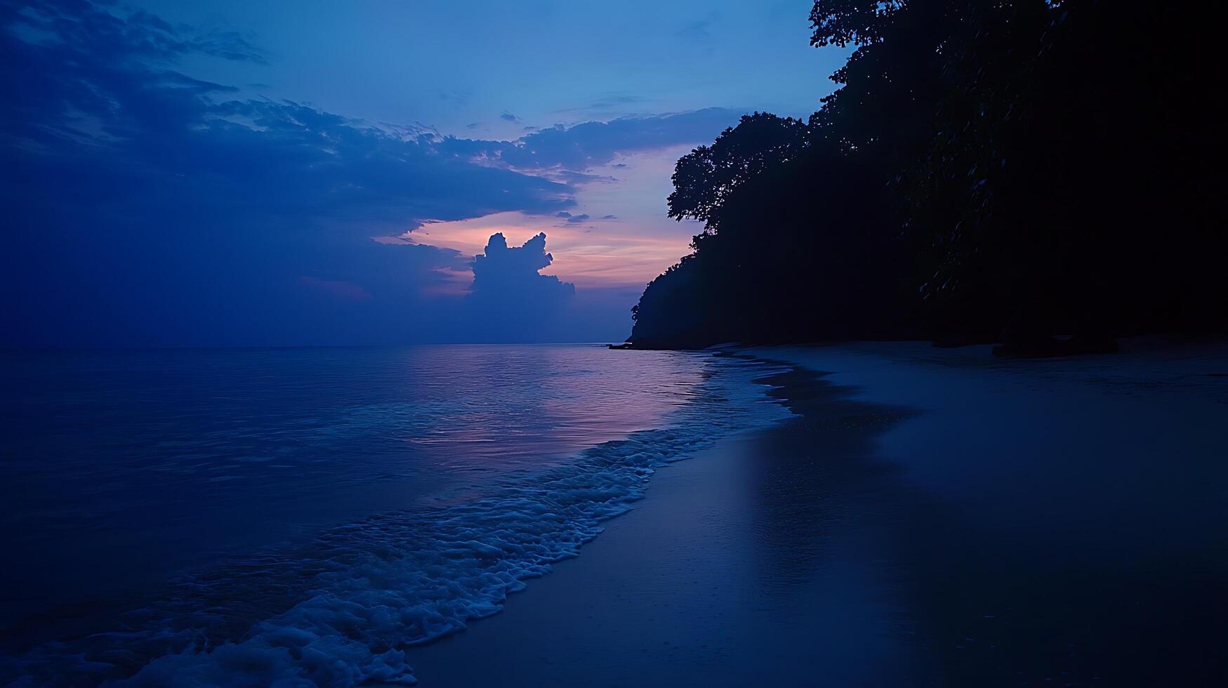Serene Blue Hour Beach and Ocean at Dusk. A peaceful tropical beach scene unfolds with gentle waves lapping the shore under a vibrant twilight sky. photo