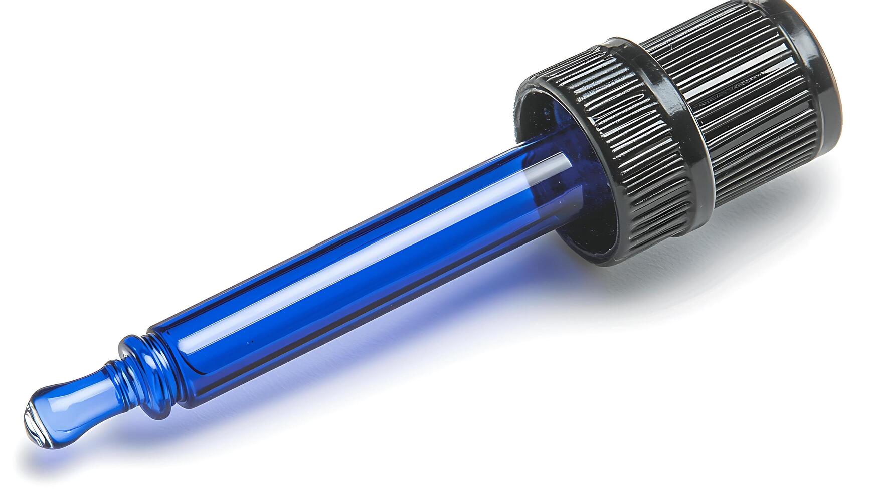 Blue Glass Dropper with Black Cap Isolated on White. A precise tool for dispensing liquids, this blue glass dropper features a textured black cap for a secure grip. photo