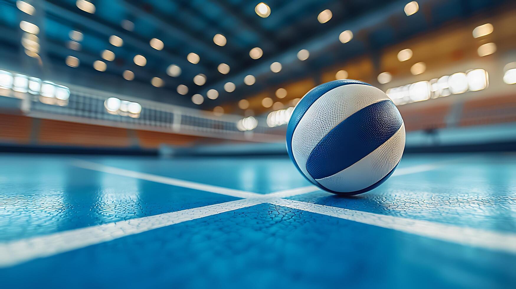 A detailed close up of a volleyball on a bright blue court. The background shows a blurred sports arena with warm lights. photo