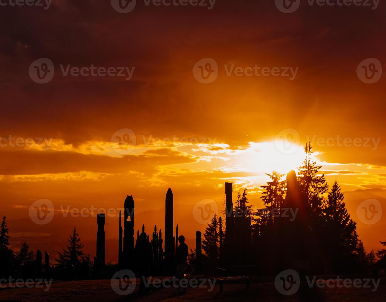 Spectacular sunset view over silhouettes of tall structures and trees at a scenic location photo