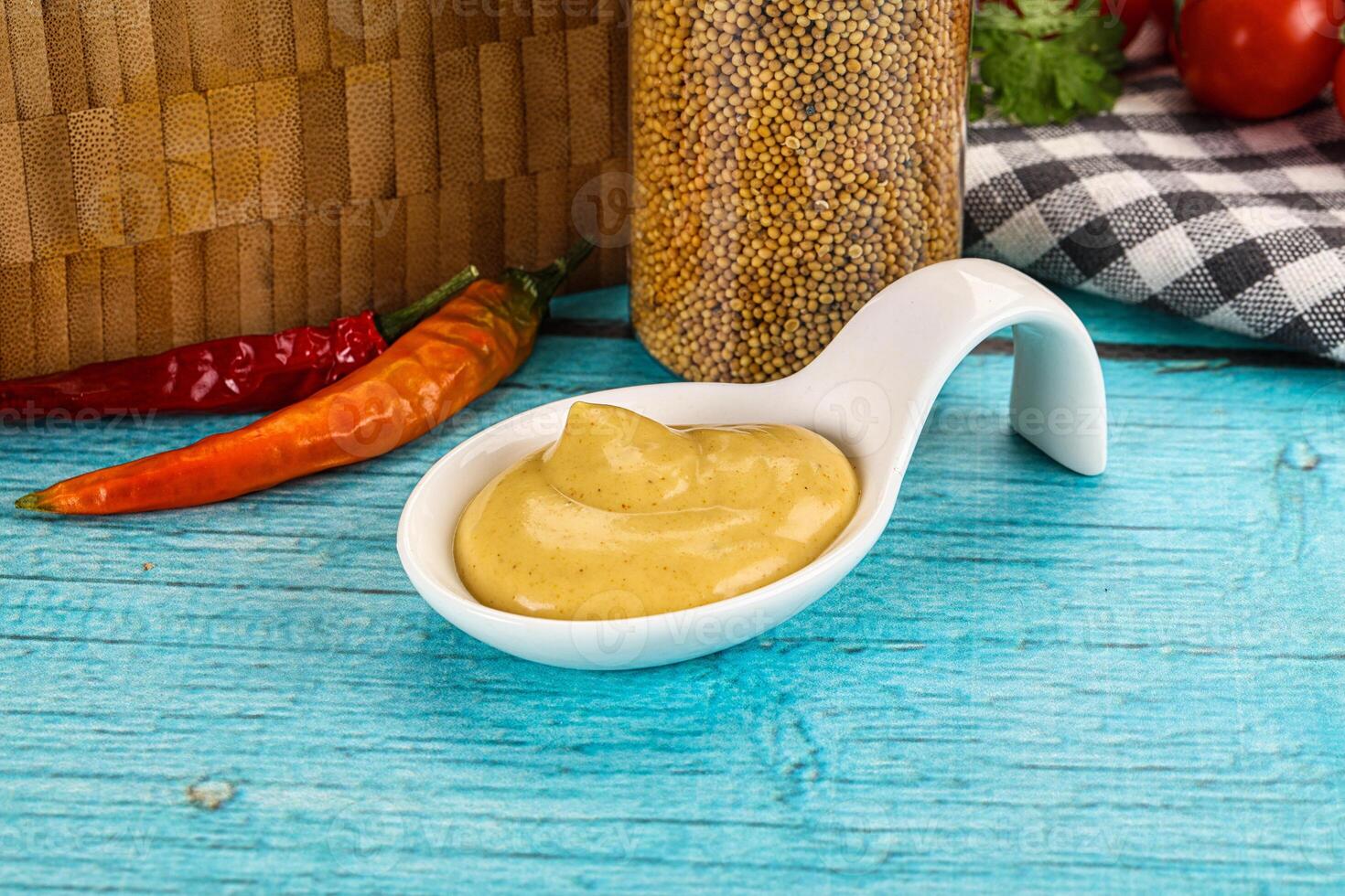 Ketchup in a spoon on a wooden table photo