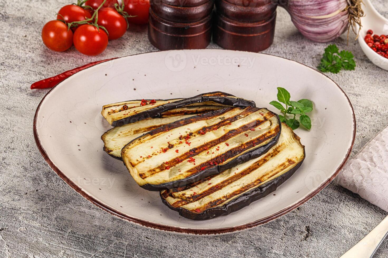 A plate of grilled eggplant with a knife and a fork photo