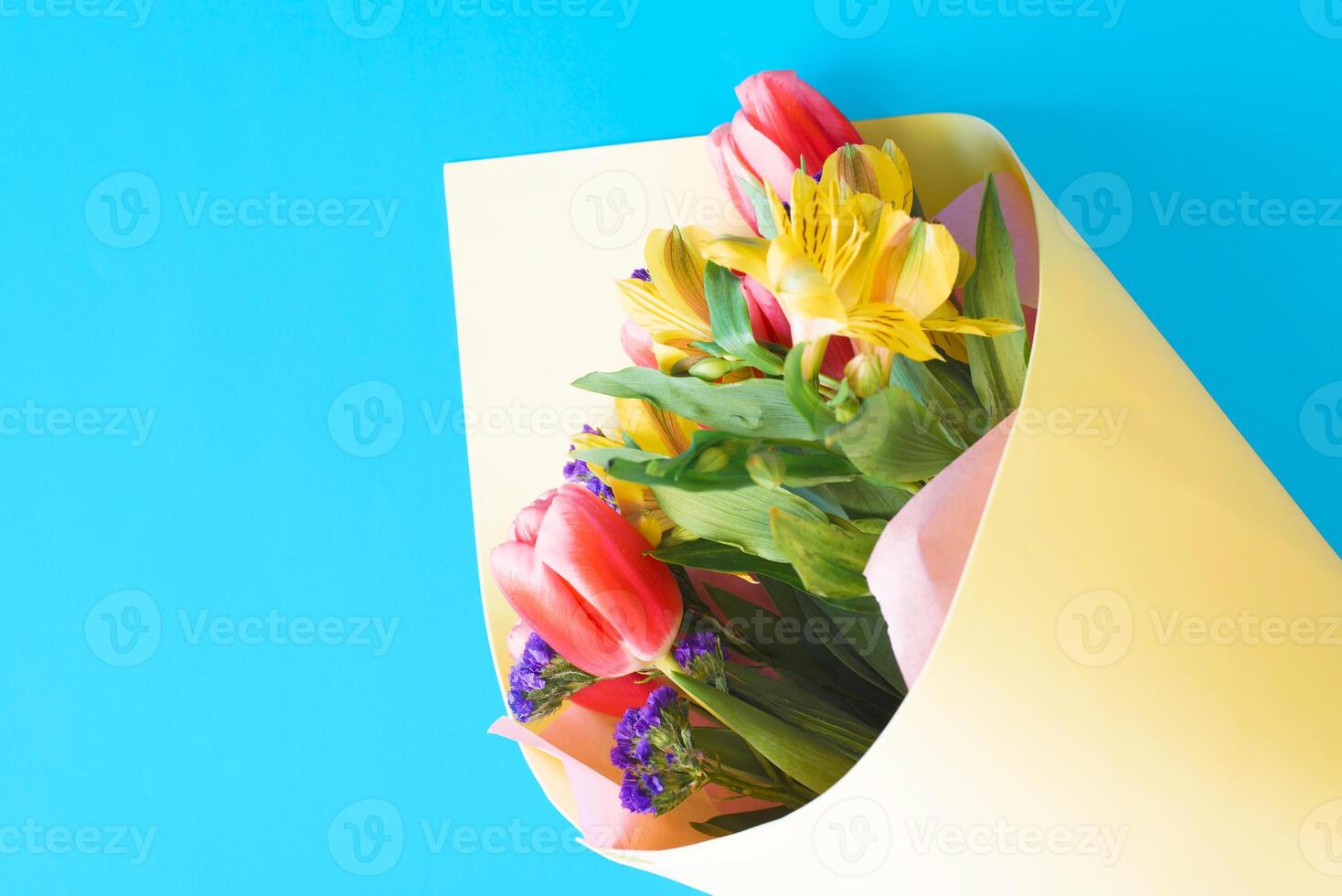 A bouquet of flowers in a paper bag on a blue background photo