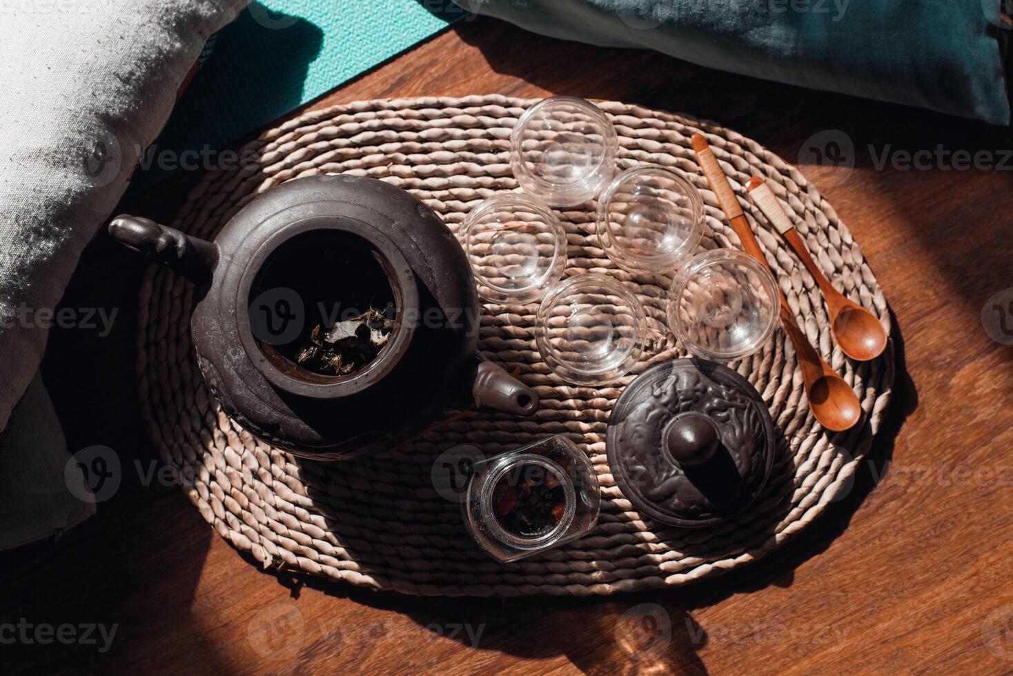 Tea ceremony set on a tray indoors, top view, selective focus. Clay teapot, herbal tea, mugs and wooden spoons. photo