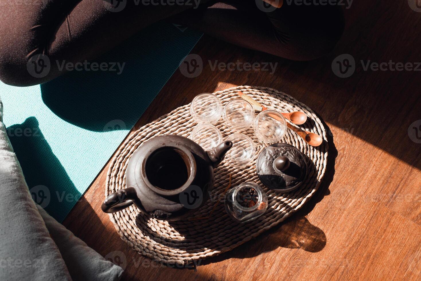 Tea ceremony set. Clay teapot, mugs, wooden spoons on a tray indoors, top view photo