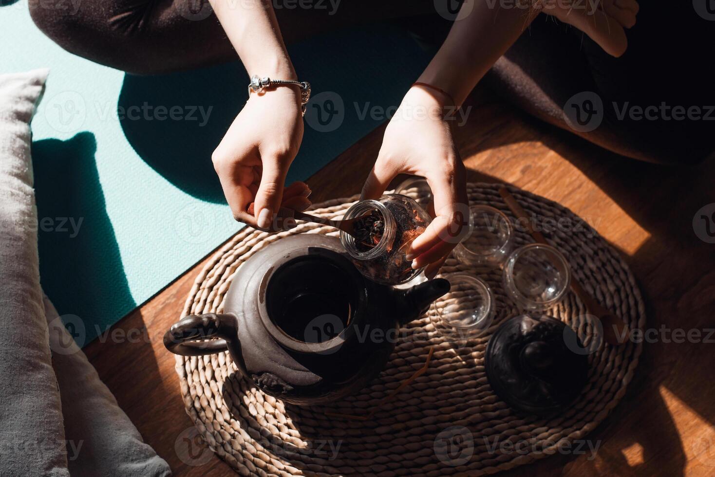 A person sitting on the floor with a tea pot photo