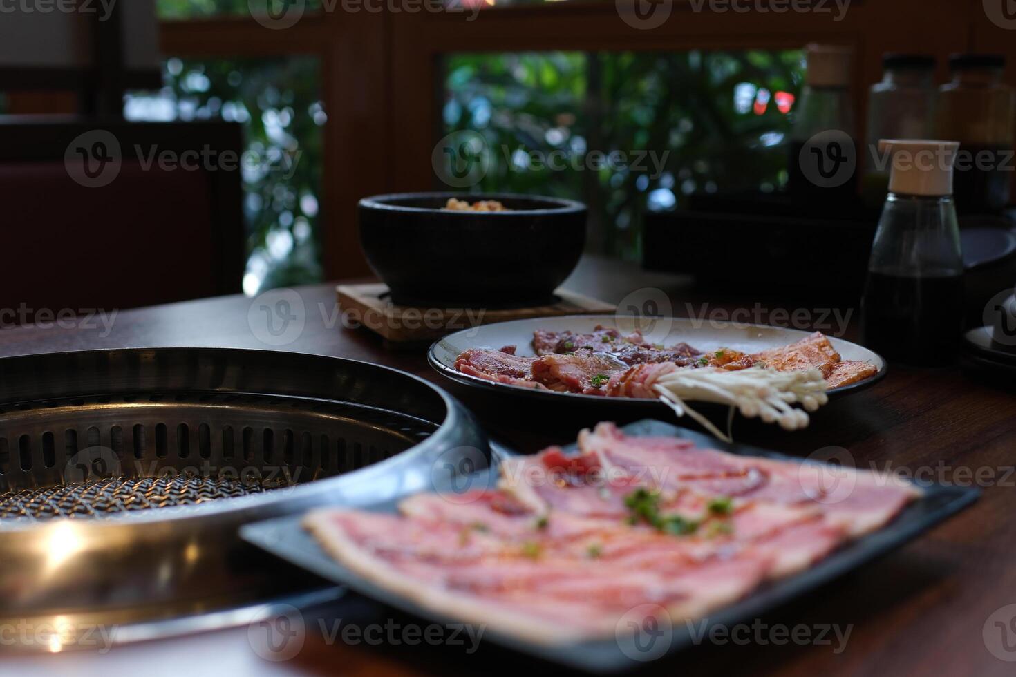 Chinese spicy hotpot soup. Plate with raw meat slides of beef at the table in a restaurant. Typical hot pot herbal cuisine with fresh and delicious dishes in chafing dish at Taiwan-Dan photo