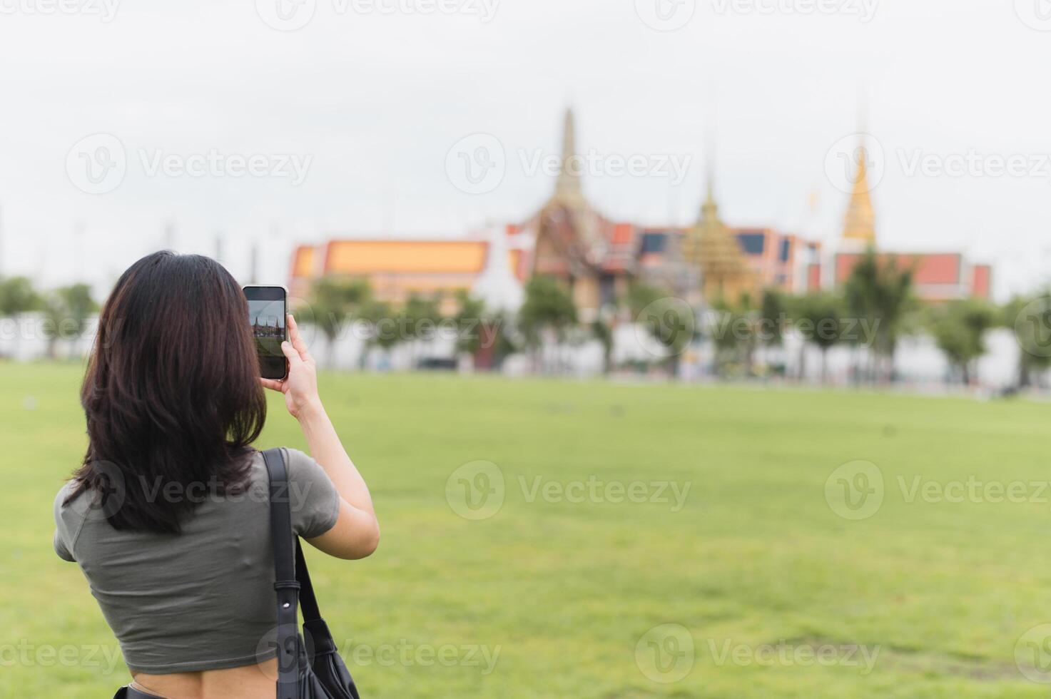 Happy southeast asian woman teenager blogger on solo world travel tourism in Bangkok Thailand take photo with smartphone. An asia local cultural experience for an explorer concept