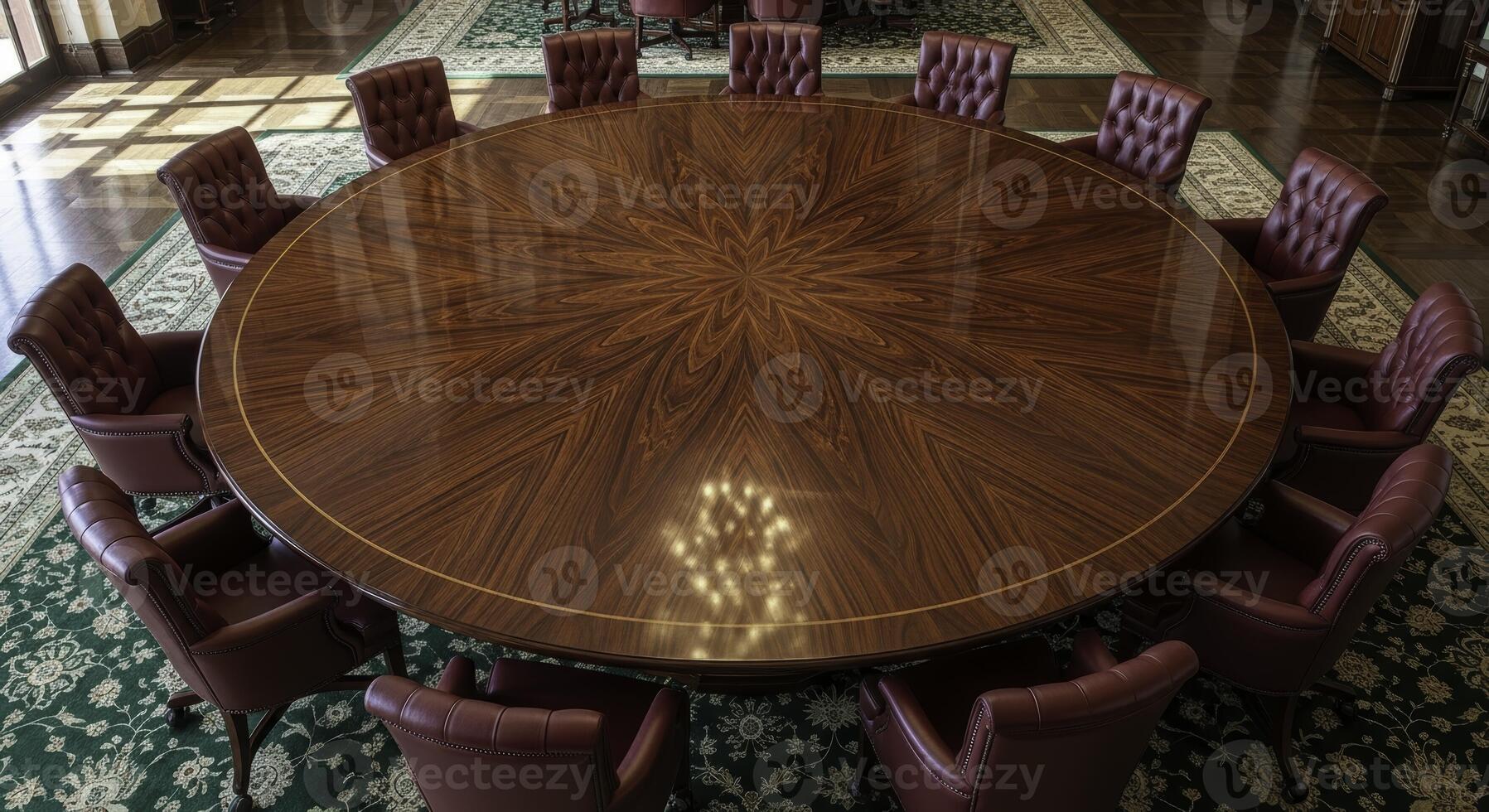 Large circular polished dark wood meeting table with leather chairs in boardroom photo