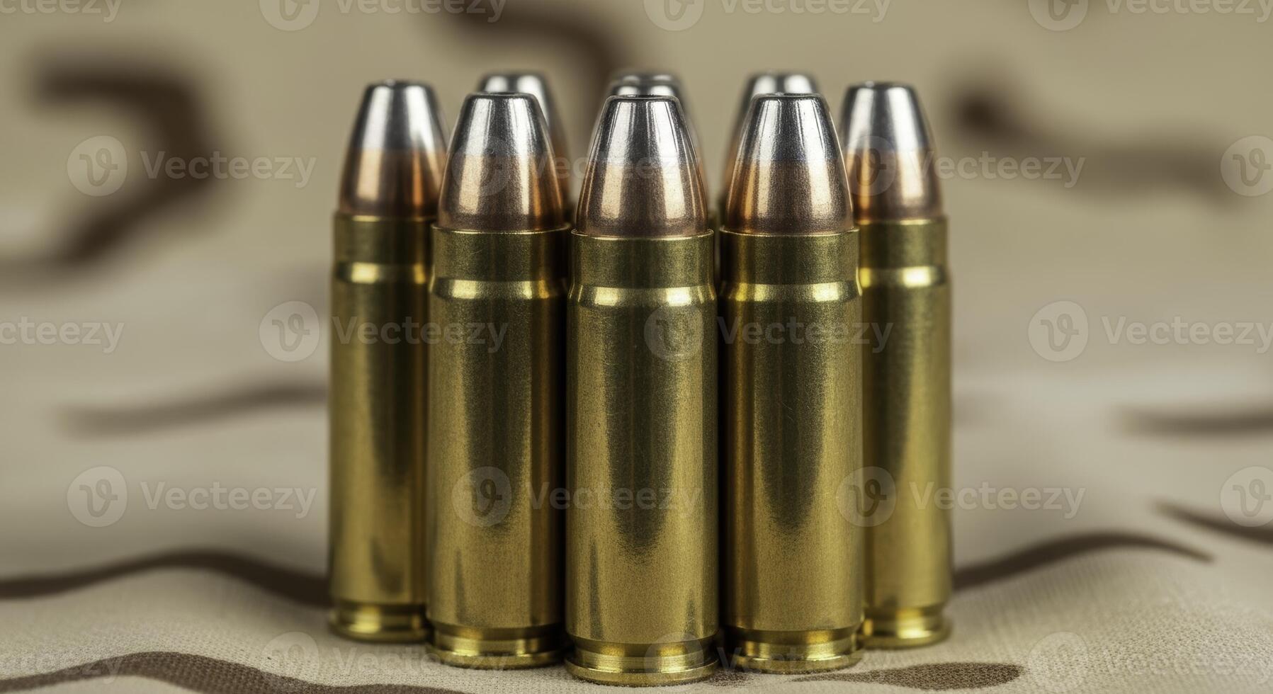 Seven .45 caliber ammunition rounds standing upright on camouflage fabric photo