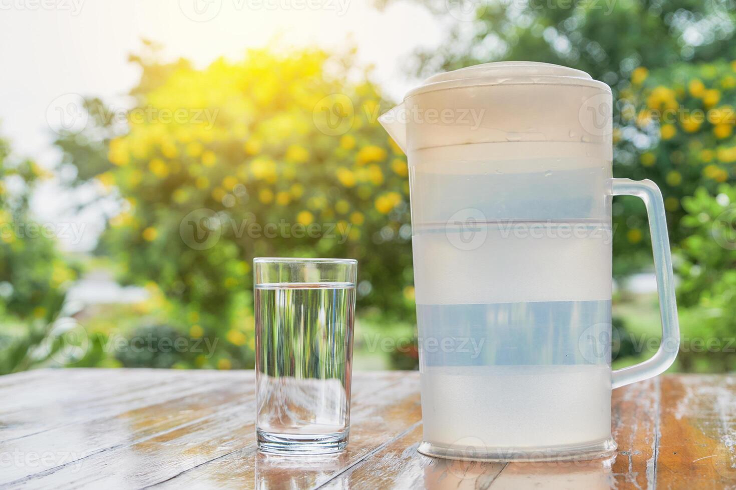 a pitcher of water and a glass of water on a table photo