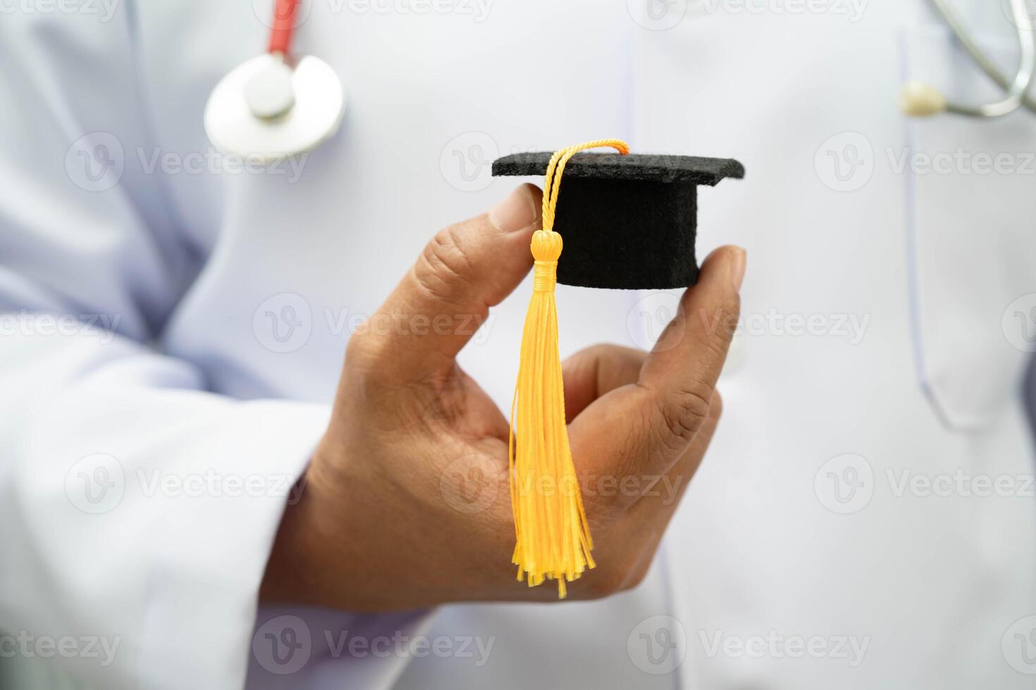 woman doctor holding graduation hat in hospital, Medical education. photo