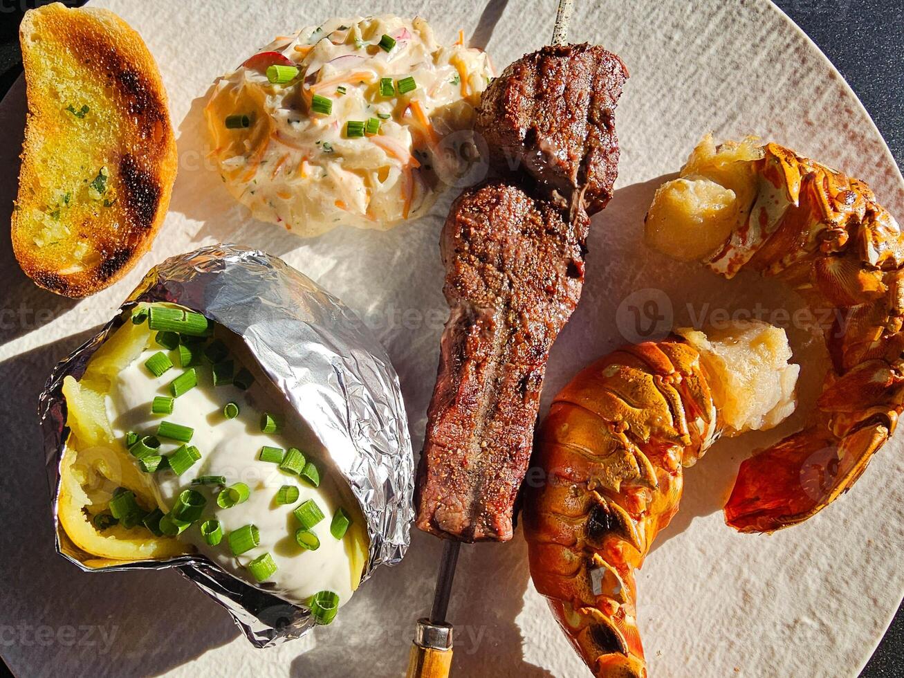 white plate with fillet steak and Lobster tails photo