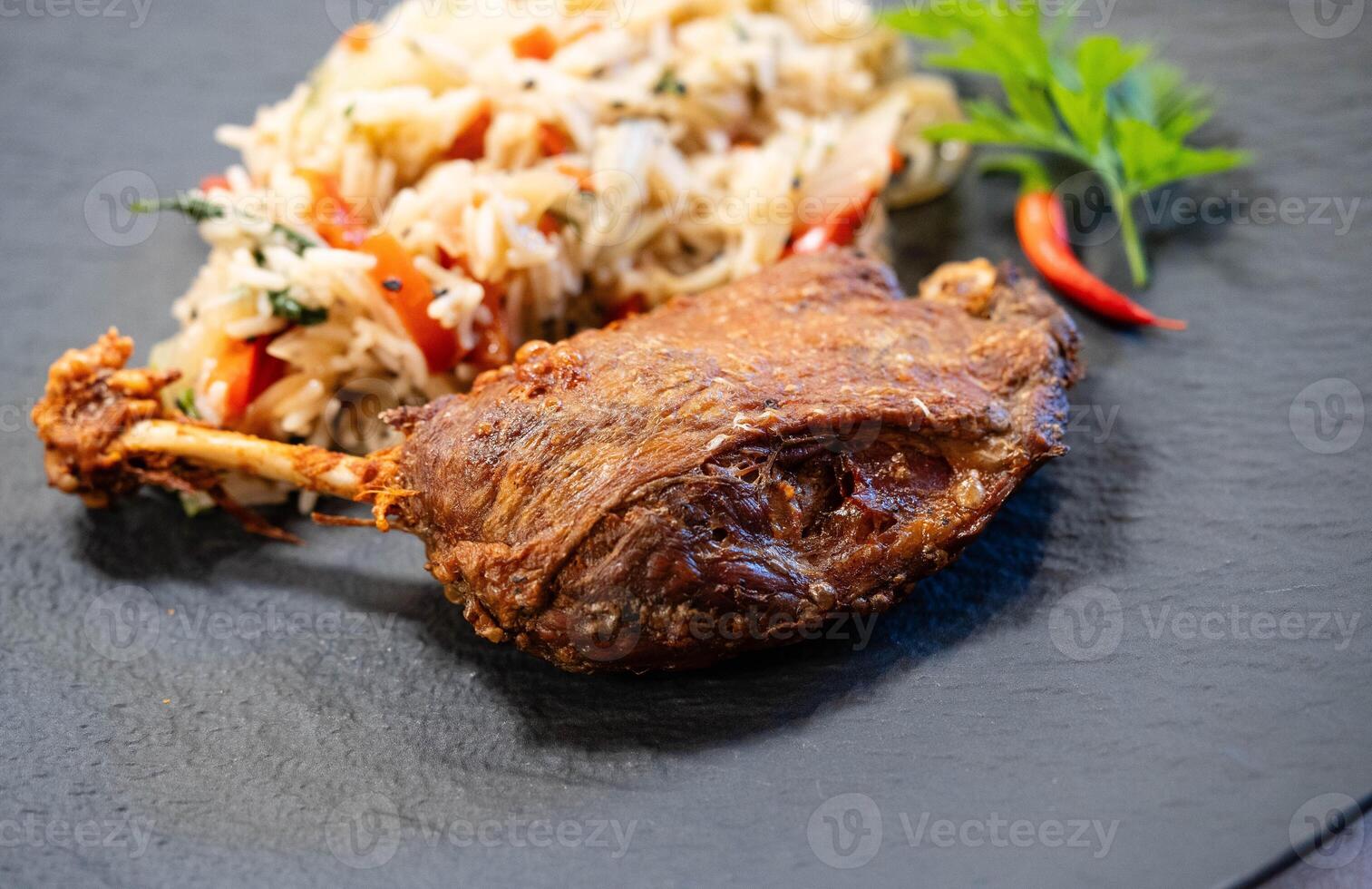 black plate with crispy roasted duck leg photo
